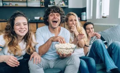 Familia mirando peli en el sofá.