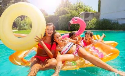 Adolescentes jugando con flotadores en una piscina.