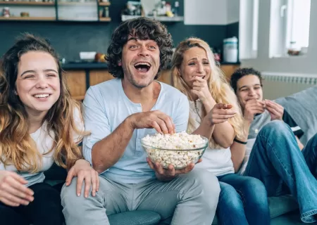 Familia mirando peli en el sofá.