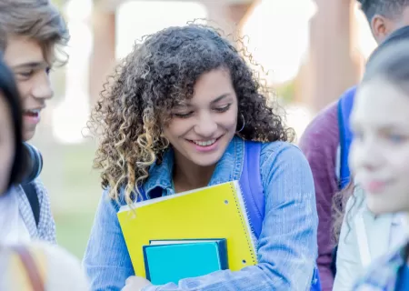 Chica con la carpeta saliendo de clase