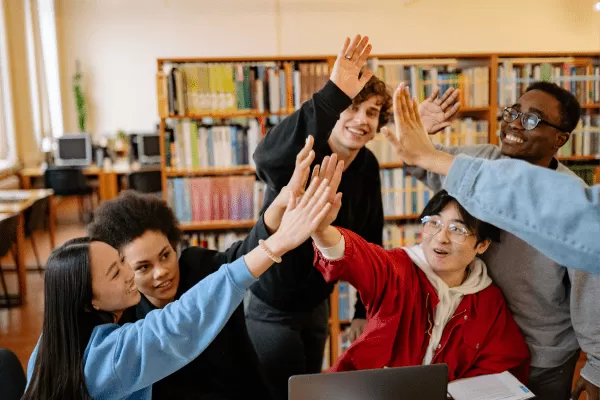 Cinc adolescents xoquen les mans en una biblioteca